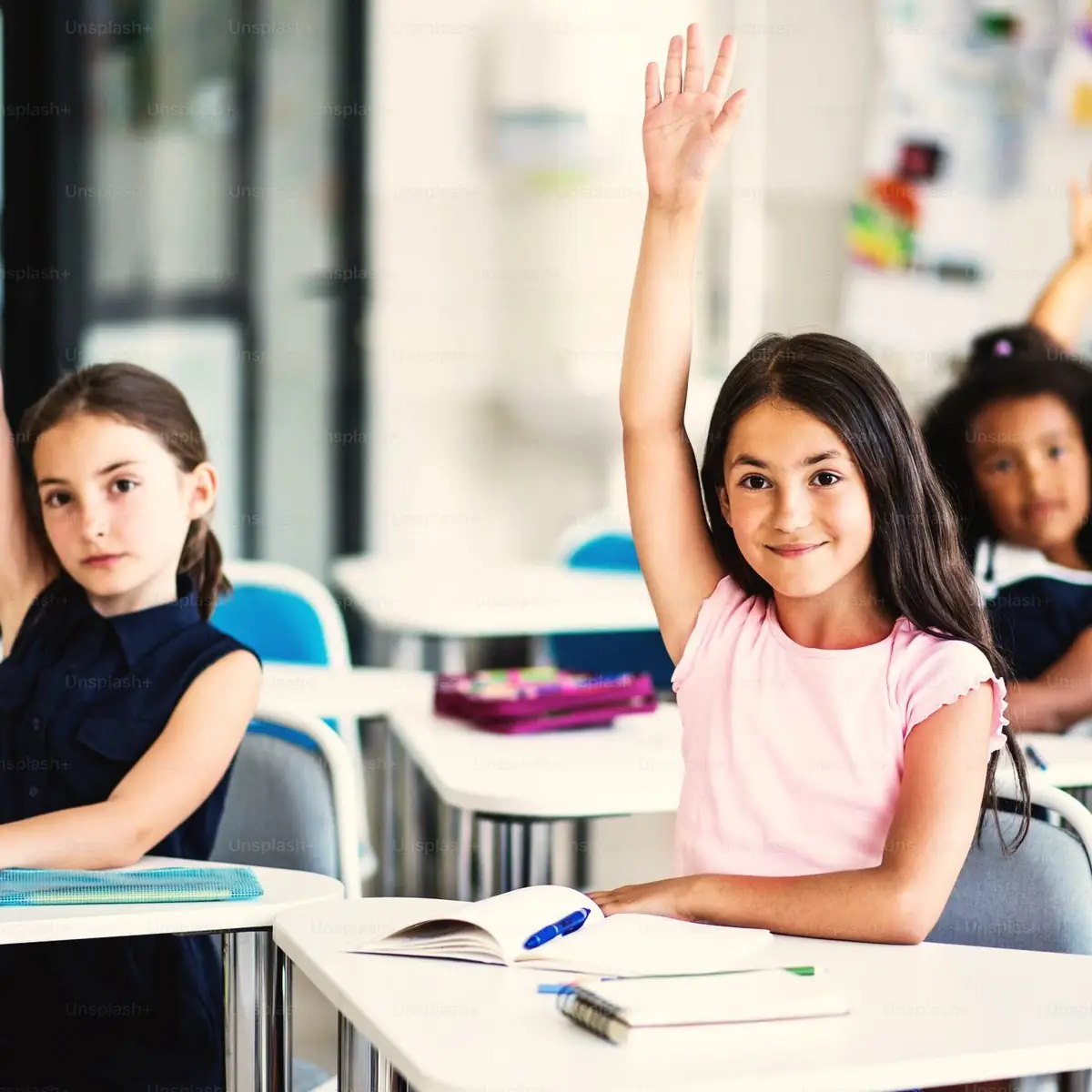 Students raising their hands in class