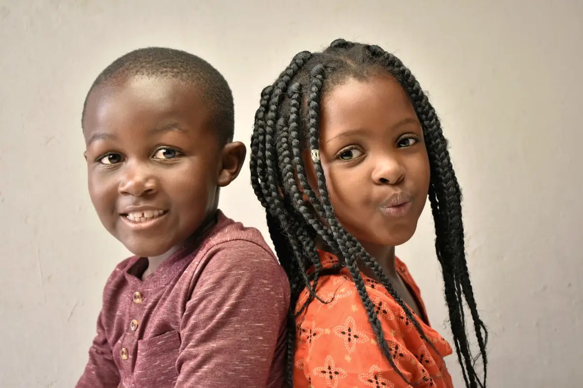 Two children sharing a laugh over their work